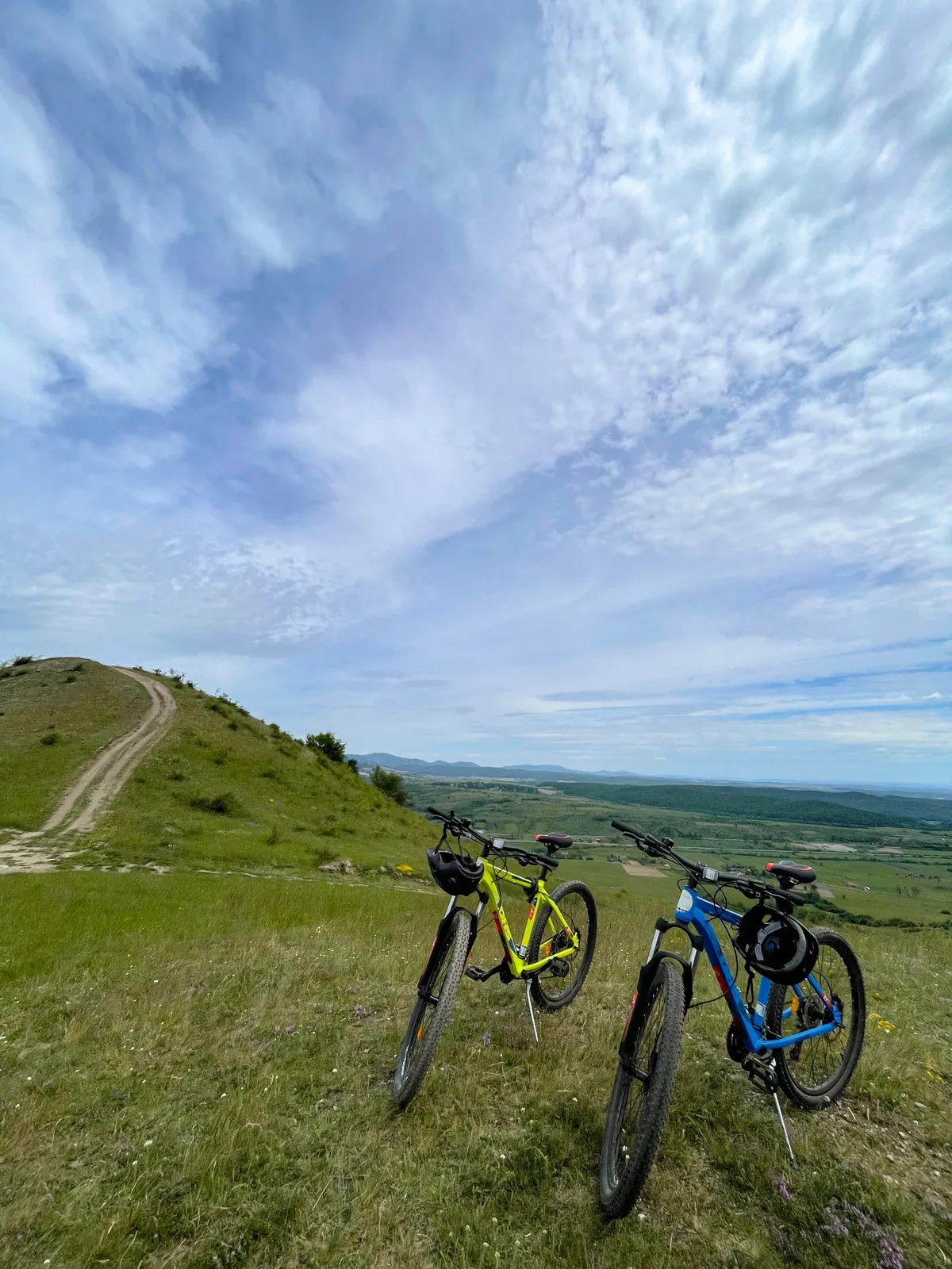 Două biciclete pe un deal, cu vedere spre vale